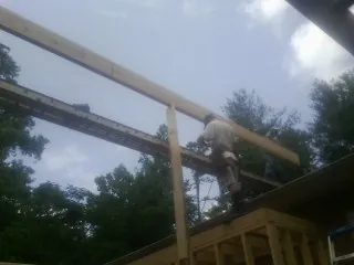 Carpenter setting a ridge beam over a new addition frame — Ice Dam Removal by Roofing Brothers in Pompeys Pillar