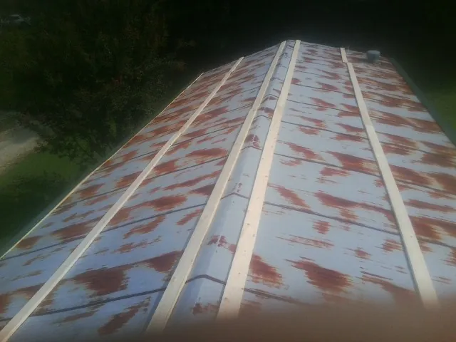 Rusted metal roof panels with new wood purlins before replacement — Storm Damage Roof Repair in Pompeys Pillar by Roofing Brothers